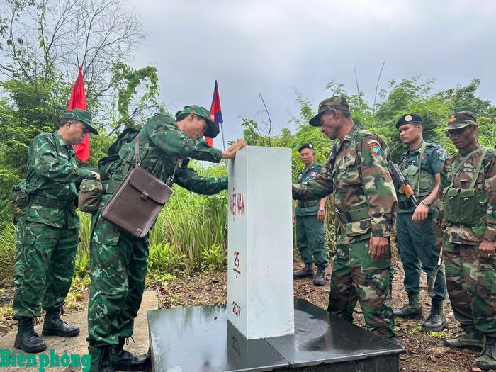 Lực lượng hai bên vệ sinh, tu bổ cột mốc. Ảnh: Thanh Bình