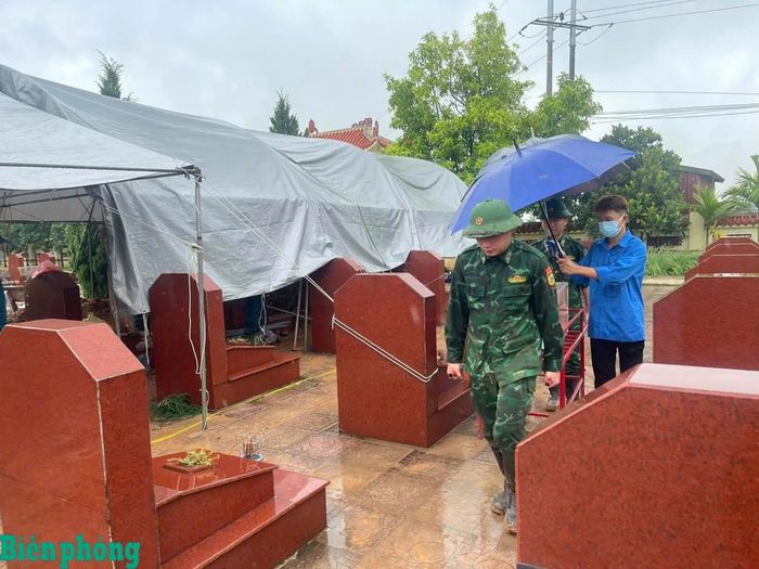 Dù thời tiết mưa lớn, cán bộ, chiến sĩ Trường Trung cấp 24 Biên phòng vẫn khẩn trương thực hiện nhiệm vụ tại nghĩa trang liệt sĩ. Ảnh: Đơn vị cung cấp