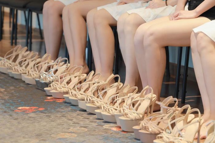 Trong phòng, những đôi giày cao gót được xếp ngay ngắn bên cạnh nhau. Vừa đặt đồ xuống, họ nhanh chóng thay giày, buộc tóc, chỉnh trang phục rồi nhập vào đội hình.