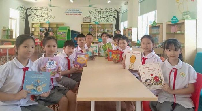 Học sinh Trường Tiểu học xã Tiên Yên bên những cuốn sách được trao tặng.