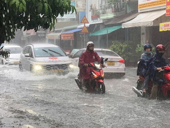  Ôtô rẽ sóng nước trên đường ngập trong chiều Chủ Nhật.