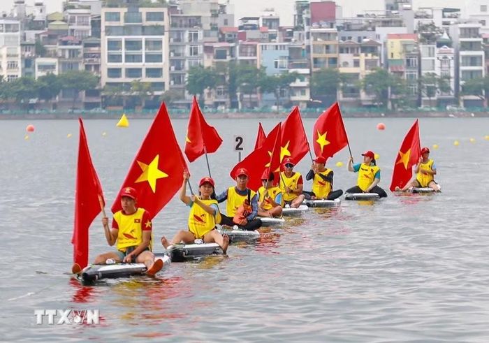 Các đội thuyền diễu hành trên mặt nước Hồ Tây, tạo nên khung cảnh sôi động trong ngày hội thể thao. (Ảnh: Khánh Hòa/TTXVN)
