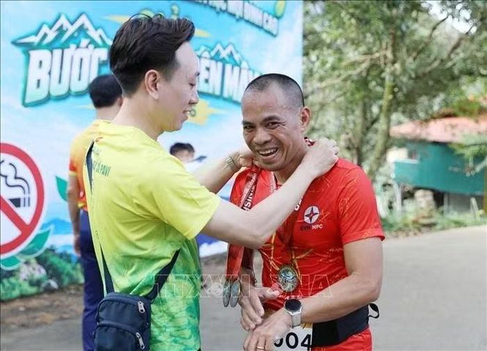 Ban tổ chức trao huy chương hoàn thành về đích cự ly 5km cho các VĐV.