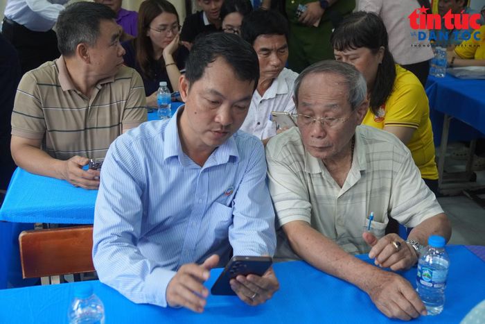 Cán bộ hướng dẫn người dân cài đặt, sử dụng các ứng dụng số ngay trên điện thoại cá nhân.
