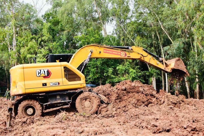 Máy móc vận chuyển đất phục vụ công tác tìm kiếm.