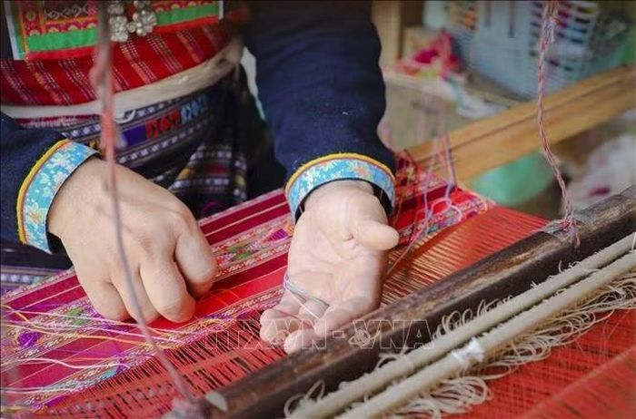 Từ những sợi chỉ đơn sắc, qua kỹ thuật dệt thủ công, các hoa văn cầu kỳ dần hiện lên trên mặt vải. Ảnh: Xuân Tư/TTXVN