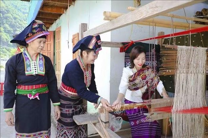 Du khách trải nghiệm dệt thổ cẩm tại bản Pa Xa Lào dưới sự hướng dẫn của người dân địa phương. Ảnh: Xuân Tư/TTXVN