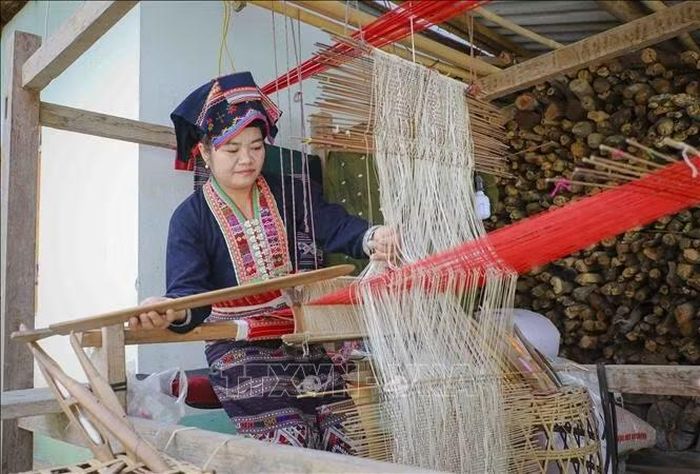 Chị Lò Thị Vân, bản Pa Xa Lào, xã Thanh Yên, thực hiện các công đoạn dệt thổ cẩm truyền thống của đồng bào dân tộc Lào. Ảnh: Xuân Tư/TTXVN