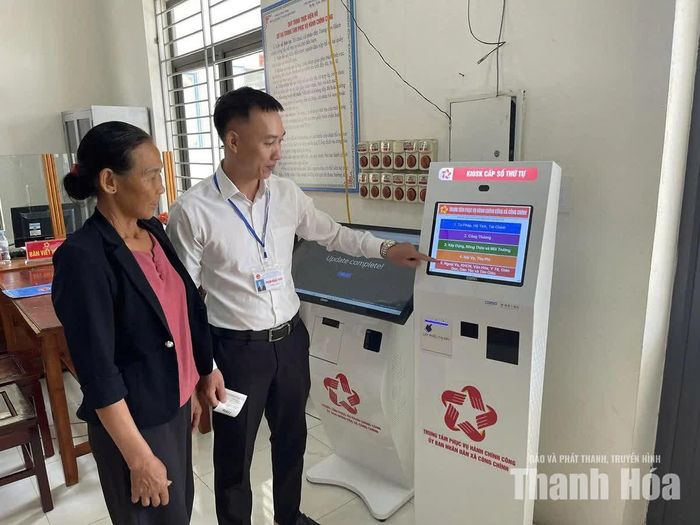 Cán bộ Trung tâm Phục vụ hành chính công xã Công Chính hướng dẫn người dân sử dụng kiosk lấy số thứ tự thực hiện thủ tục hành chính.
