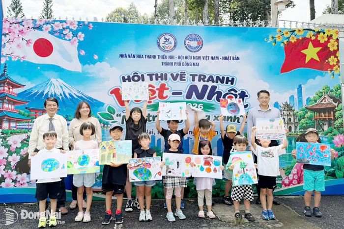 Đại biểu chụp hình với các em thiếu nhi người Nhật Bản và sản phẩm tranh sau khi hoàn thành. Ảnh: ĐVCC