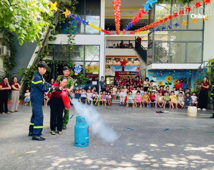 Giáo viên thực hành dập lửa bằng bình chữa cháy xách tay.