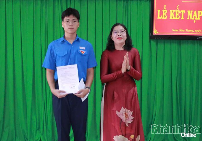 Cô Đặng Ngọc Lệ Thy - Bí thư Chi bộ trao quyết định kết nạp đảng viên mới cho em Vũ Minh Huy.
