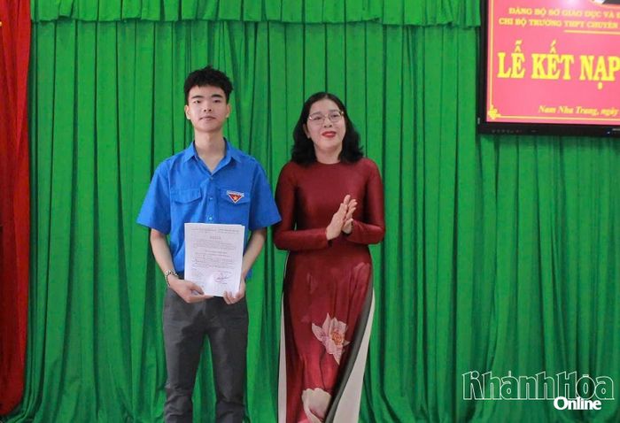 Cô Đặng Ngọc Lệ Thy - Bí thư Chi bộ trao quyết định kết nạp đảng viên mới cho em Trần Nguyễn Khánh Duy.