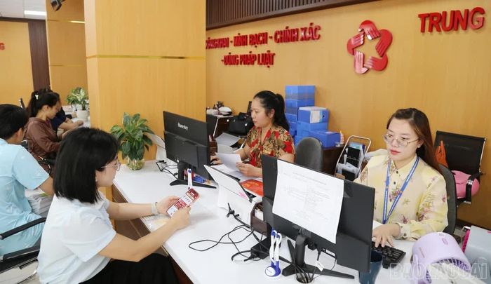 Cán bộ, công chức hướng dẫn người dân nộp hồ sơ thủ tục hành chính trực tuyến.