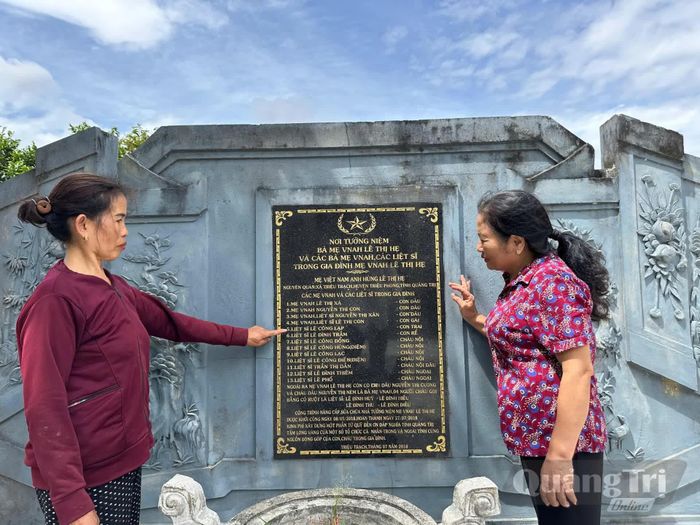 Bà Lê Thị Đẳng (góc phải ảnh) bên tấm bình phong nơi ghi danh đại gia đình kiên trung - Ảnh: Đ.V