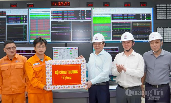Đồng chí Lê Mạnh Hùng, Bộ trưởng Bộ Công thương và đồng chí Bùi Hoàng Phương, Chủ tịch UBND tỉnh tặng quà động viên cán bộ, kỹ sư tại Trung tâm Điện lực Quảng Trạch - Ảnh: N.H