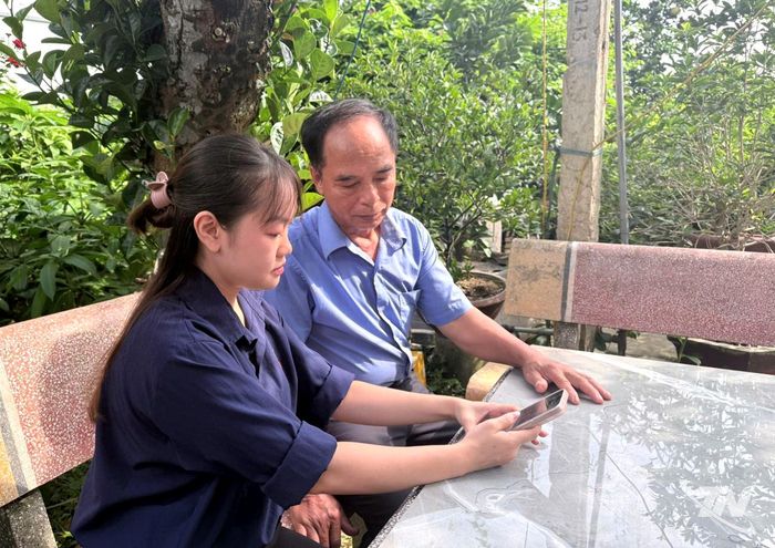Thành viên Tổ công nghệ số cộng đồng hướng dẫn đảng viên sử dụng ứng dụng Sổ tay đảng viên điện tử trên điện thoại thông minh