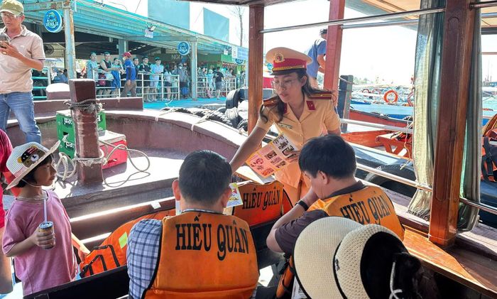 CSGT đường thủy Khánh Hòa phát tờ rơi tuyên truyền về ATGT đường thủy trên các chuyến tàu du lịch.
