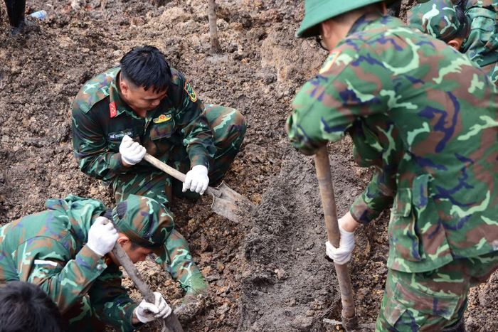 Các cán bộ chiến sĩ cẩn trọng, tỉ mỉ tìm kiếm từng mẫu hài cốt liệt sĩ.