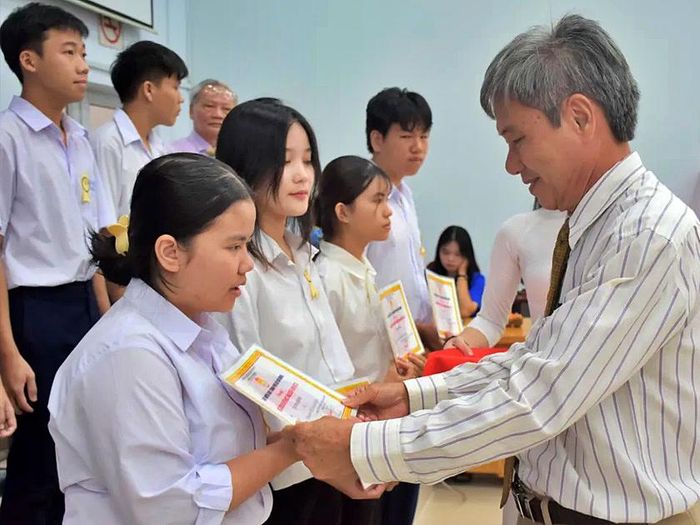 Phó Chủ tịch Hội Khuyến học Thành phố Hồ Chí Minh Hồ Cảnh Hạnh trao học bổng cho các em học sinh.