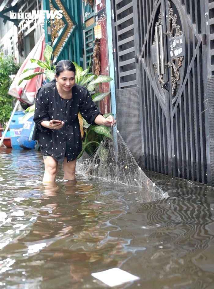 Đáng chú ý, nước ngập kéo dài còn khiến cá rô đồng từ khu vực kênh theo dòng nước tràn vào các con hẻm. Một số người dân mua lưới, tranh thủ giăng bắt cá ngay giữa khu vực ngập nước.