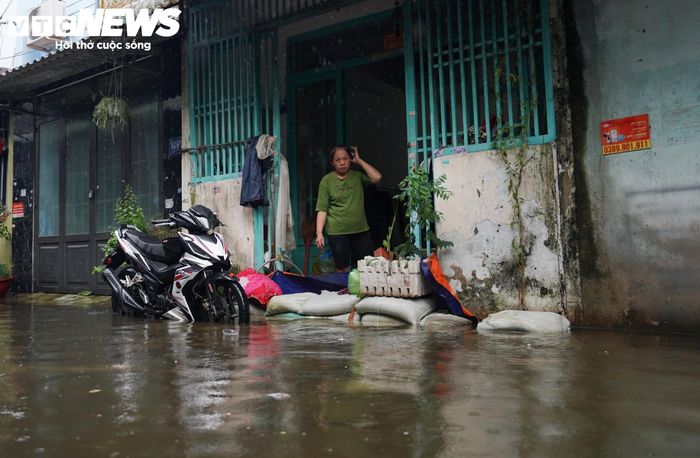 Bà Nguyễn Thị Huyền, người đã sống tại khu vực này hơn 30 năm, cho biết đây là lần đầu tiên bà chứng kiến nước ngập tràn vào nhà kéo dài nhiều ngày như vậy. “Nước dâng cao hơn một tuần đến trưa nay mới rút, thấy vậy bà con lối xóm tranh thủ dọn dẹp. Ai dè vừa dọn xong thì trời lại mưa, nước lại ngập tràn vào nhà, chúng tôi chỉ biết bất lực nhìn nước tràn vào”, bà Huyền nói.