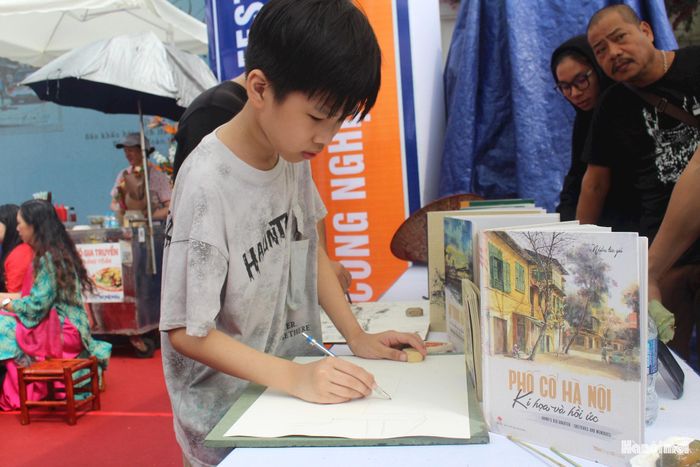 Không gian ký họa truyền cảm hứng cho các bạn nhỏ. Em Phạm Đức Duy say mê cầm bút, thử ghi lại những hình ảnh nhà Thủy Tạ ven Hồ Gươm.