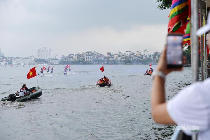Người dân ghi lại màn trình diễn cờ Tổ quốc trên hồ Tây bằng điện thoại. Ảnh: Tuấn Anh