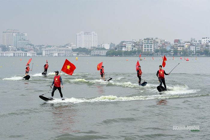 Đoàn SUP mang cờ đỏ sao vàng nối tiếp nhau trên mặt hồ Tây. Ảnh: Tuấn Anh