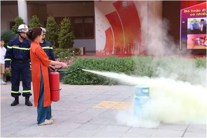 Hình ảnh lực lượng Cảnh sát PCCC&CNCH hướng dẫn Đội viên Đội PCCC cơ sở và cán bộ nhân viên nhà trường cách sử dụng phương tiện chữa cháy ban đầu