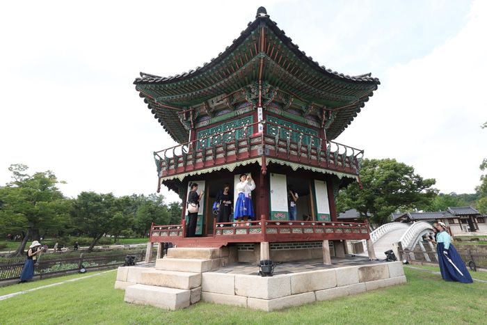  Du khách tham gia tour đặc biệt tại đình Hyangwonjeong trong khuôn viên cung Gyeongbok, quận Jongno, trung tâm Seoul, hôm 2/10. Ảnh: Yonhap. 