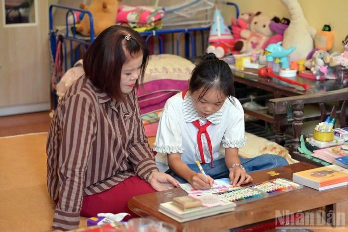 Hai cô trò cùng làm bài tập mỹ thuật sau giờ tới trường trên căn gác nhỏ của gia đình N.T.H. Cô học trò lớp 4 rất thích môn học này. (Ảnh: LINH PHAN)