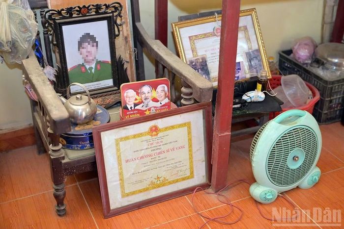 Những vật dụng mà gia đình N.T.H. lưu giữ được sau những cơn lũ dữ, hiện đang đặt tại tầng 2 căn nhà xiêu vẹo. Trong số này, có tấm ảnh thờ của bố em. (Ảnh: LINH PHAN)