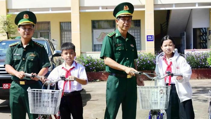 Lãnh đạo Đồn Biên phòng Bù Đốp trao xe đạp cho các em học sinh. (Ảnh: HT)