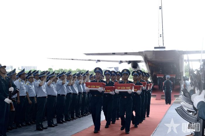 Vận chuyển mẫu hài cốt liệt sĩ từ máy bay xuống.