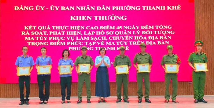 Phó Bí thư Thường trực Đảng ủy phường Huỳnh Sơn Hải và Chủ tịch UBND phường Trần Tường Vân trao khen thưởng cho các cá nhân.