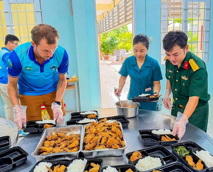Anh Constantine Roginski nấu món Việt, trao những phần cơm nghĩa tình là niềm vui và việc làm ý nghĩa. Ảnh: MẠNH THẮNG