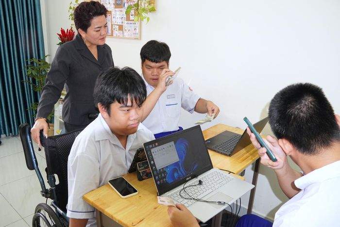 Cô Nguyễn Thị Thanh Huệ hướng dẫn học sinh thao tác nhận diện mệnh giá tiền trên ứng dụng SgBE. Ảnh: QUANG HUY