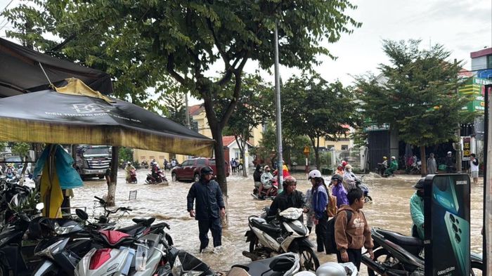  Cơn mưa bất chợt gây ngập đường khiến người dân đi lại khó khăn 