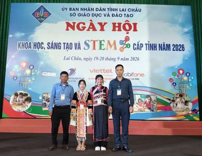 Hai học sinh Chang Trúc Linh và Chu Mỳ Ly chụp ảnh lưu niệm cùng giáo viên hướng dẫn đề tài.