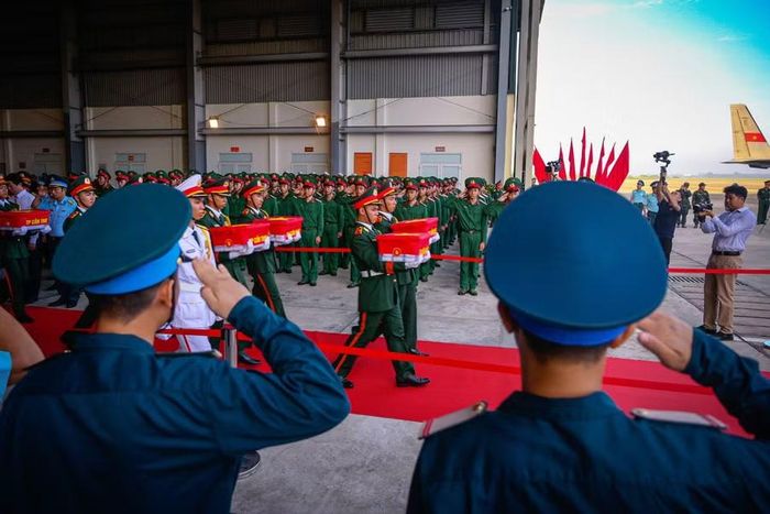 Cán bộ, chiến sĩ Không quân thực hiện nghi thức chào khi những thùng mẫu hài cốt liệt sĩ lần lượt được đưa lên máy bay.