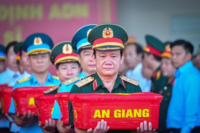Trung tướng Hồ Văn Thái, Chính ủy Quân khu 9, trực tiếp nâng thùng mẫu hài cốt liệt sĩ trong nghi thức vận chuyển, bàn giao. Mỗi thùng mẫu được trao nhận trang trọng, chặt chẽ trước khi đưa lên máy bay.