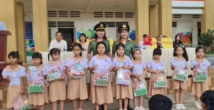 Ban Phụ nữ và Hội Phụ nữ cơ sở Thanh tra Công an tỉnh An Giang tặng BHYT và quà cho học sinh.