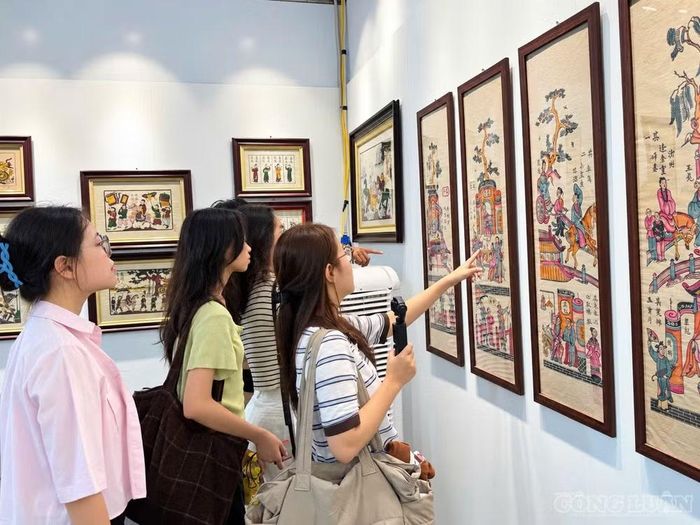 Người dân và du khách quốc tế tìm hiểu tranh dân gian Việt Nam tại lễ hội. Ảnh: Diệu Linh