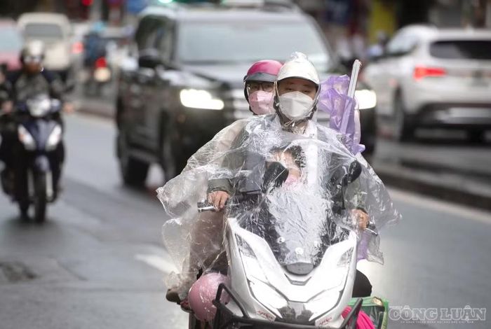 Một số người mặc thêm áo mưa để chắn gió lạnh, đồng thời tránh những hạt mưa phùn trong quá trình di chuyển.