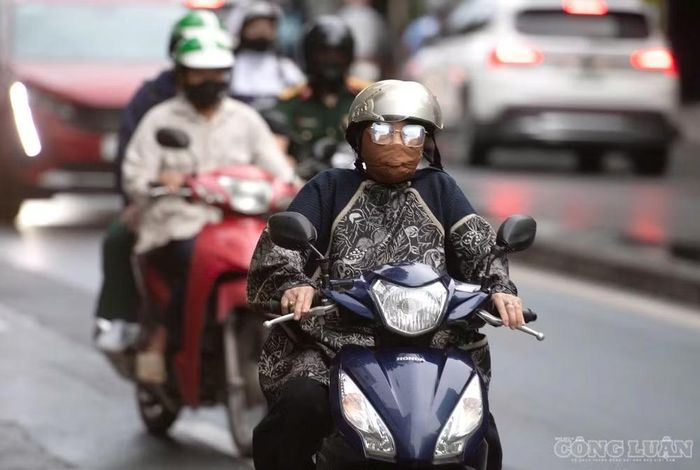 Người dân mặc kín người khi di chuyển trên đường, hạn chế gió lạnh.
