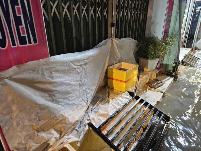 Người dân trên đường Phan Huy Ích tận dụng mọi vật liệu để che chắn, sợ nước tràn vào nhà