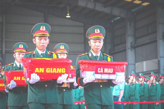 Đại diện lãnh đạo các đơn vị bàn giao, đưa mẫu sinh phẩm hài cốt liệt sĩ lên máy bay để vận chuyển ra Hà Nội giám định ADN phục vụ xác định danh tính liệt sĩ.