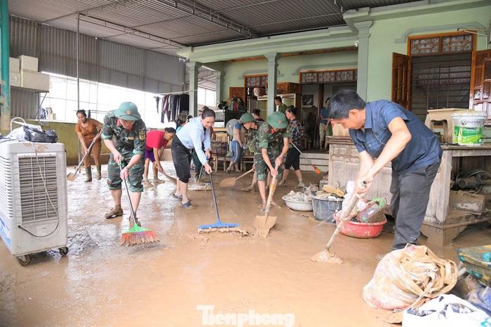 Cán bộ, chiến sĩ Sư đoàn 324 giúp người dân dọn dẹp nhà cửa sau bão lũ.