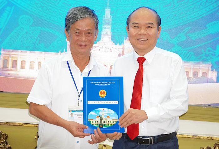Ông Trần Văn Bảy trao quyết định cho thôi giữ chức vụ Hiệu trưởng Trường Đại học Sài Gòn đối với ông Phạm Hoàng Quân. Ảnh: Quang Huy.